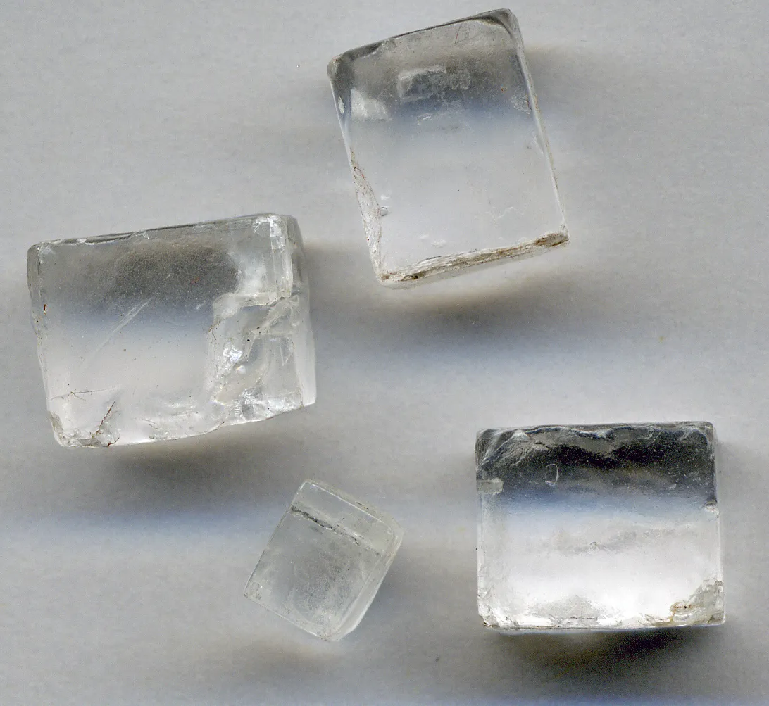 La misma sal, pero crecida en la naturaleza sin prisa: halita. Cubos transparentes de varios centímetros, con las caras planas.