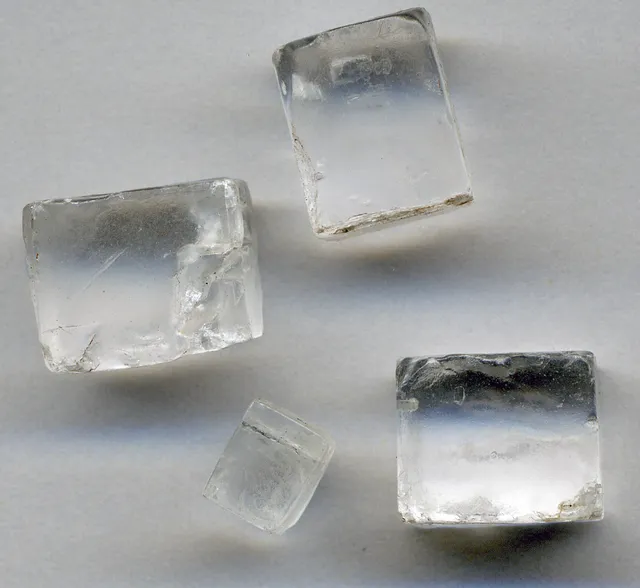 La misma sal, pero crecida en la naturaleza sin prisa: halita. Cubos transparentes de varios centímetros, con las caras planas.