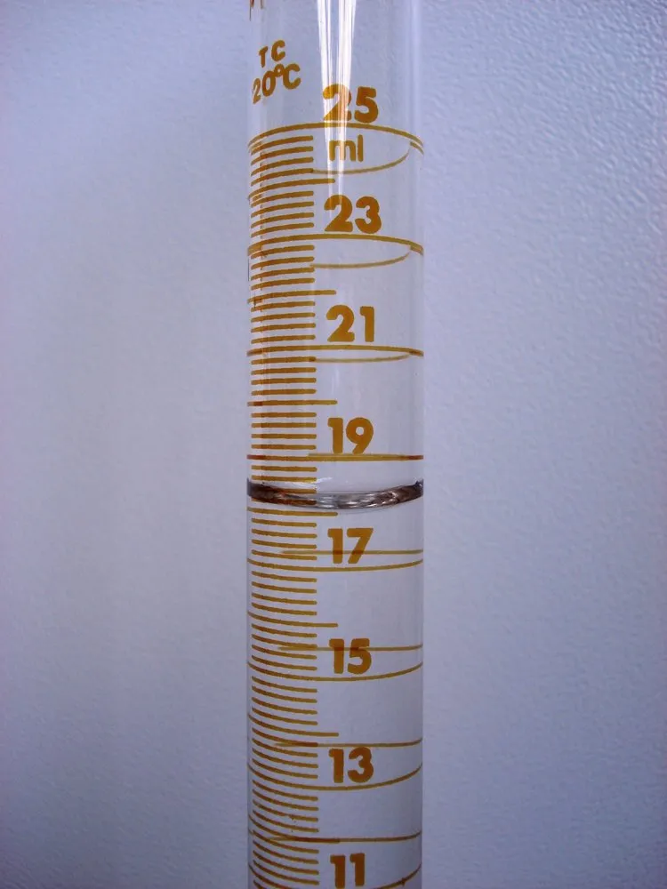 Una probeta de verdad con 18 mL de agua: la superficie se curva hacia abajo y se lee su parte de abajo